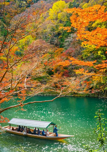 Boatman peddelen de boot op Arashiyama bos uitzicht in de herfst langs Katsura rivier. Kyoto, Japan. — Stockfoto