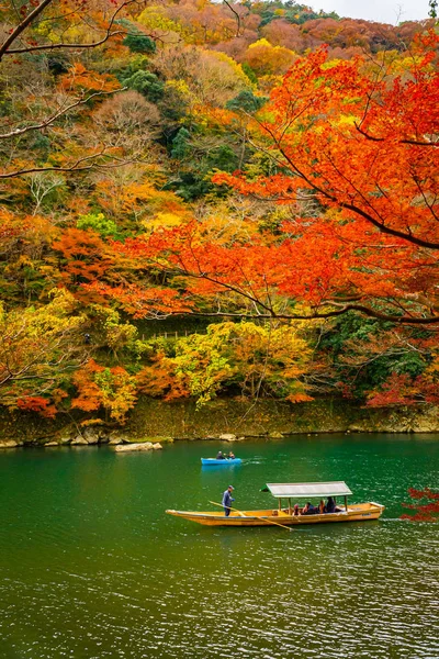 Boatman peddelen de boot op Arashiyama bos uitzicht in de herfst langs Katsura rivier. Kyoto, Japan. — Stockfoto