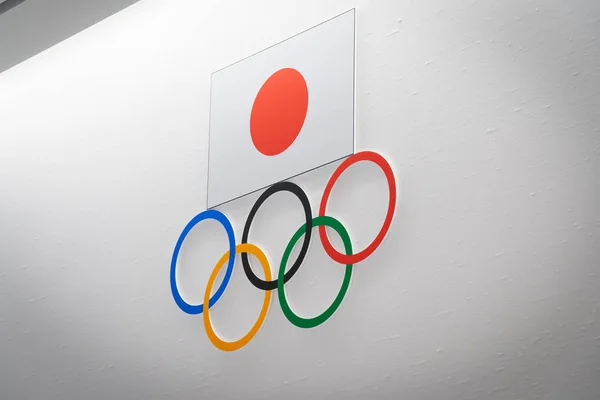 TOKYO, JAPAN - NOVEMBER 26, 2019: Olimpiade lima cincin dengan bendera nasional Jepang pada latar belakang dinding putih di museum Olimpiade Jepang, distrik Shinjuku - Tokyo, Jepang . — Stok Foto