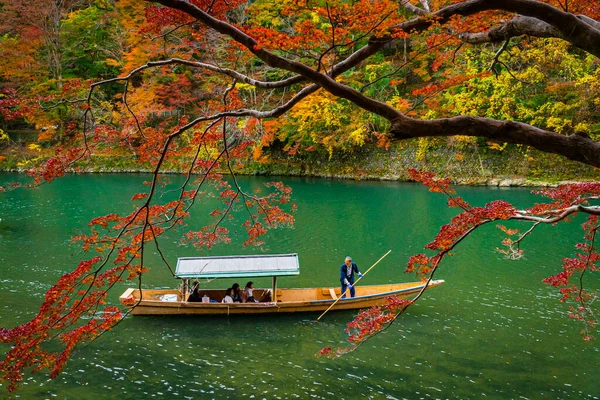 Boatman peddelen de boot op Arashiyama bos uitzicht in de herfst langs Katsura rivier. Kyoto, Japan. — Stockfoto