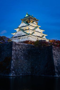 Osaka kalesi ya da Japonya 'nın Osaka şehrinde karanlık mavi gökyüzü arka planına sahip Himeji kalesi..