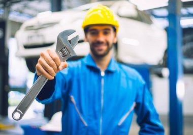 Tamirciler tamirhanede ingiliz anahtarı tutuyor. Otomobil servisi kavramları