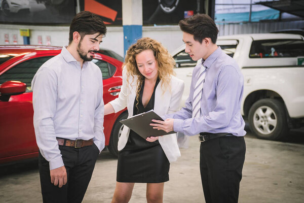 Успешная деловая пара покупает новый автомобиль в автосалоне
. 