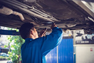 Tamirci tamirhanedeki arabayı tamir ediyor. Otomobil servisi kavramları