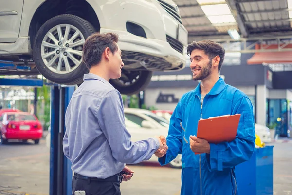 Mecánico Sujetando Portapapeles Estrechando Mano Con Propietario Del Coche Garaje —  Fotos de Stock