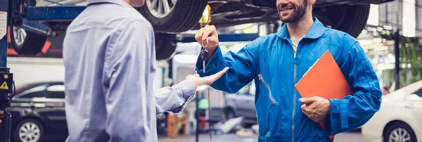 Mekaniker Holder Udklipsholderen Giver Nøglen Tilbage Til Bilejeren Værkstedet Garage Royaltyfrie stock-billeder