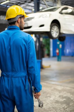 Tamirciler tamirhanede ingiliz anahtarı tutuyor. Otomobil servisi kavramları