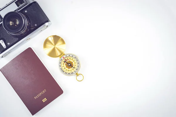 Travel accessories concepts : It's time to go to travel around the world - The image of a white background with essentials accessories - passport, compass and camera. Top view picture.