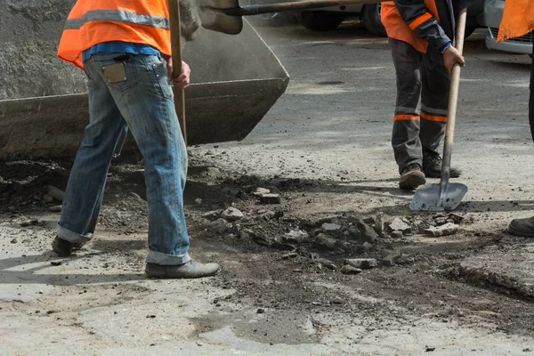 Los trabajadores limpiaron el asfalto viejo con palas. Reparación carretera —  Fotos de Stock