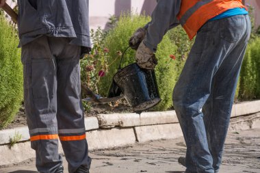 Yol onarım. İş ayrıntıları, işçi reçine yol yüzeyi asfalt karşılamak için dök.