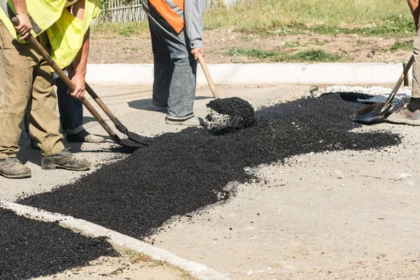 Yol onarım ayrıntılar. İşçiler yolda sıcak asfalt çukurları ile uyuya.