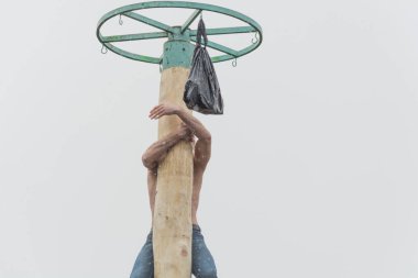 Tiraspol, Moldova - 18 Şubat 2018: ödül için ahşap bir direğe tırmanma genç adam. Slav halk pagan tatil Maslenitsa (Shrovetide) - bahar sembolik bir toplantı.