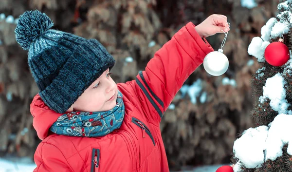 Little boy decorates a Christmas tree for Christmas — Stock Photo, Image