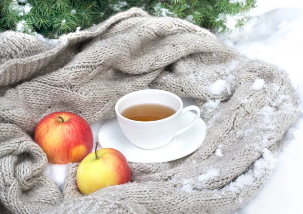 Tasse blanche de thé enveloppée dans une écharpe tricotée sur une soucoupe avec déchirure — Photo
