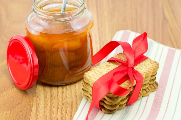 La confitura de albaricoque en el frasco de cristal con las galletas a la servilleta — Foto de Stock