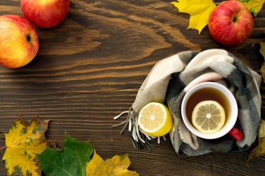 ahşap bir masa üzerinde bir atkı sarılı bir limonlu sıcak çay