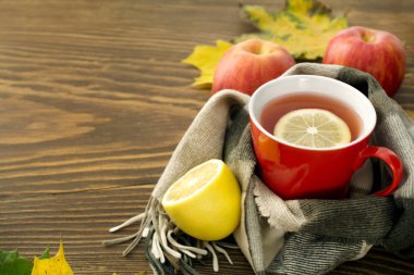 ahşap bir masa üzerinde bir atkı sarılı bir limonlu sıcak çay