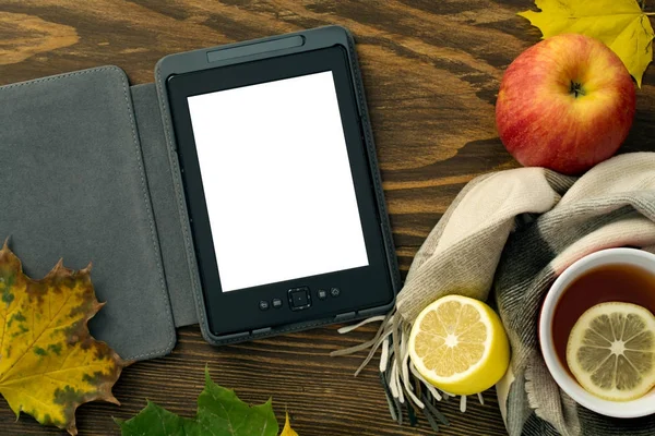 eBook ve ahşap bir masa üzerinde bir atkı sarılı bir limonlu sıcak çay
