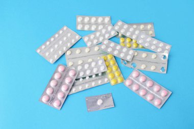 Blister paketleri tıp hap. tabletler ve kapsüller mavi arka plan üzerinde
