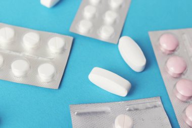 Blister paketleri tıp hap. tabletler ve kapsüller mavi arka plan üzerinde