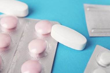 Blister paketleri tıp hap. tabletler ve kapsüller mavi arka plan üzerinde
