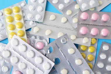 Blister paketleri tıp hap. tabletler ve kapsüller mavi arka plan üzerinde