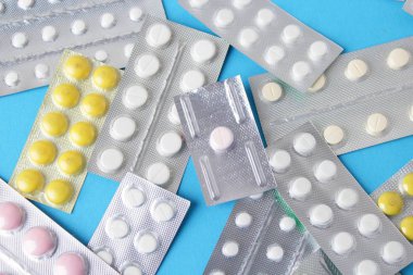 Blister paketleri tıp hap. tabletler ve kapsüller mavi arka plan üzerinde