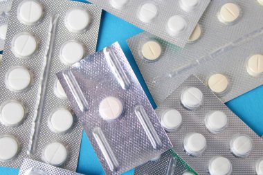 Blister paketleri tıp hap. tabletler ve kapsüller mavi arka plan üzerinde
