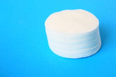 Yuvarlak pamuk kozmetik sünger pad, yün mavi bir arka plan üzerinde