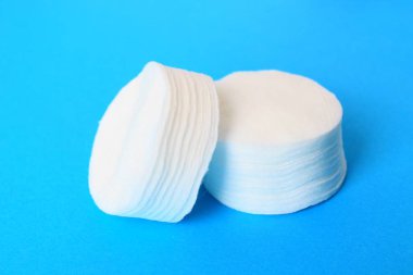 Yuvarlak pamuk kozmetik sünger pad, yün mavi bir arka plan üzerinde