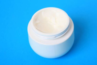 Mavi arka plan üzerinde vücut kremi ile jar