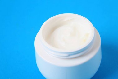 Mavi arka plan üzerinde vücut kremi ile jar