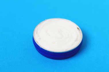 Mavi arka plan üzerinde vücut kremi ile jar