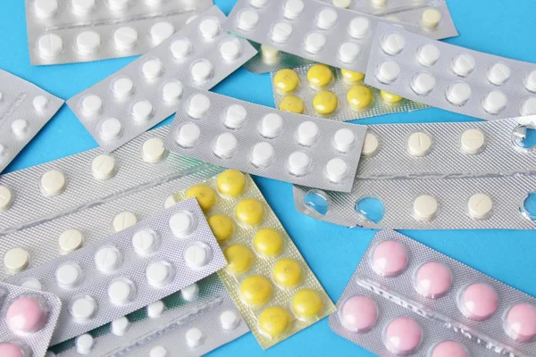 Blister paketleri tıp hap. tabletler ve kapsüller mavi arka plan üzerinde