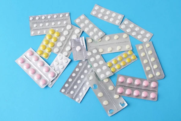 Blister paketleri tıp hap. tabletler ve kapsüller mavi arka plan üzerinde