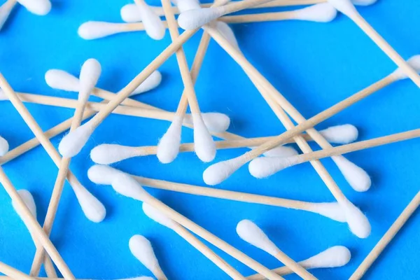 White cotton-tipped swabs, bud . Ear sticks close up on a blue background