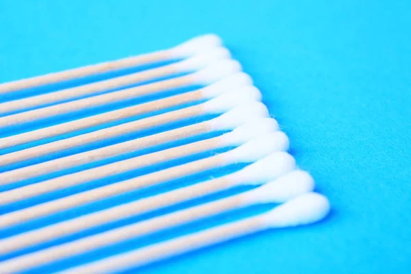 White cotton-tipped swabs, bud . Ear sticks close up on a blue background
