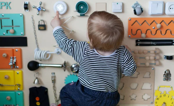 Boy playing busy-board