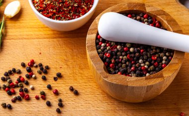Ahşap bir tahtada baharat doğrama seti: biberiye, sarımsak, biber, paprika