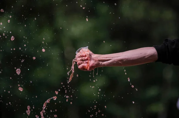 Hand with drinking water pours water. The conditions of the water and environmental crisis