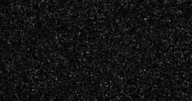 Siyah bir arkaplanda soyut uçan toz parçacıkları