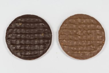 Süt ve beyaz bir arka plan üzerinde izole düz çikolata sindirim bisküvi