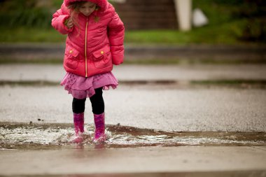 Genç bir kız California yağmur çok oynuyor.