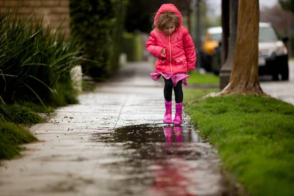 Ein junges Mädchen spielt im dringend benötigten kalifornischen Regen. — Stockfoto
