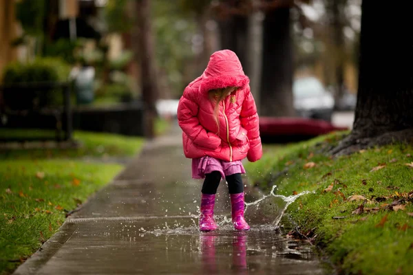 Une jeune fille joue sous la pluie californienne si nécessaire . Image En Vente