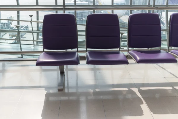 Airport terminal interior with rows of empty seats, city view an — Stockfoto