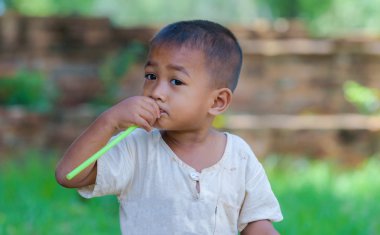 Asyalı çocuk saman içinde ağız, masum oyunla kirli ile.