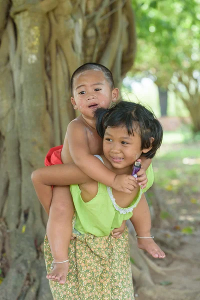 little asian boy sit on young girl\'s back ,they dress in Thai lo