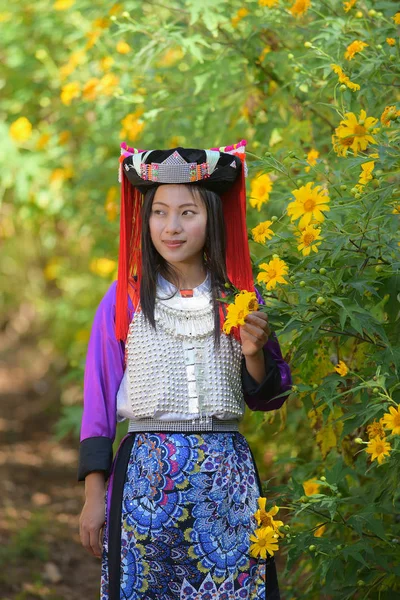 Ázsiai szép Liptai hölgy egyéni ruhában tartsa sárga Mexikó napraforgó a kezében és várom. — Stock Fotó