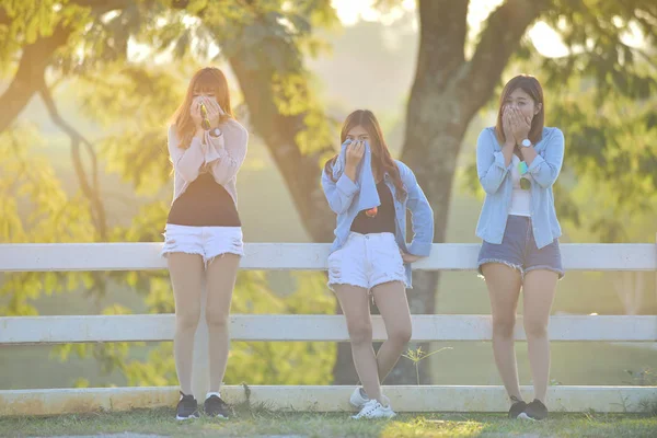 Meninas asiáticas bonitas que colocam na grama verde sob a luz do sol — Fotografia de Stock